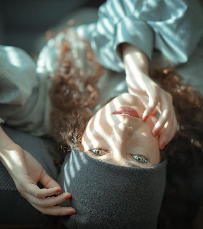 Woman in a calm state with eyes closed, surrounded by a peaceful grey atmosphere.
